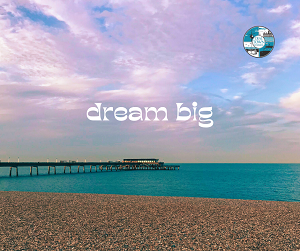 deal beach with 'dream big' written in the sky